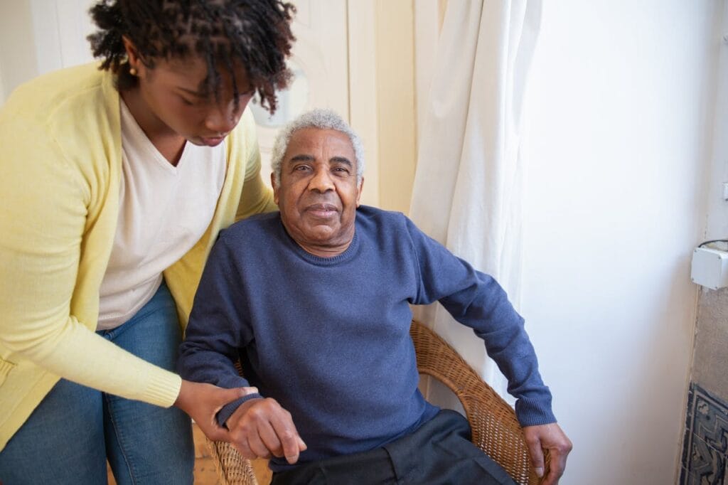 pexels photo 7551667 A woman assists an elderly man indoors, focusing on care and support.